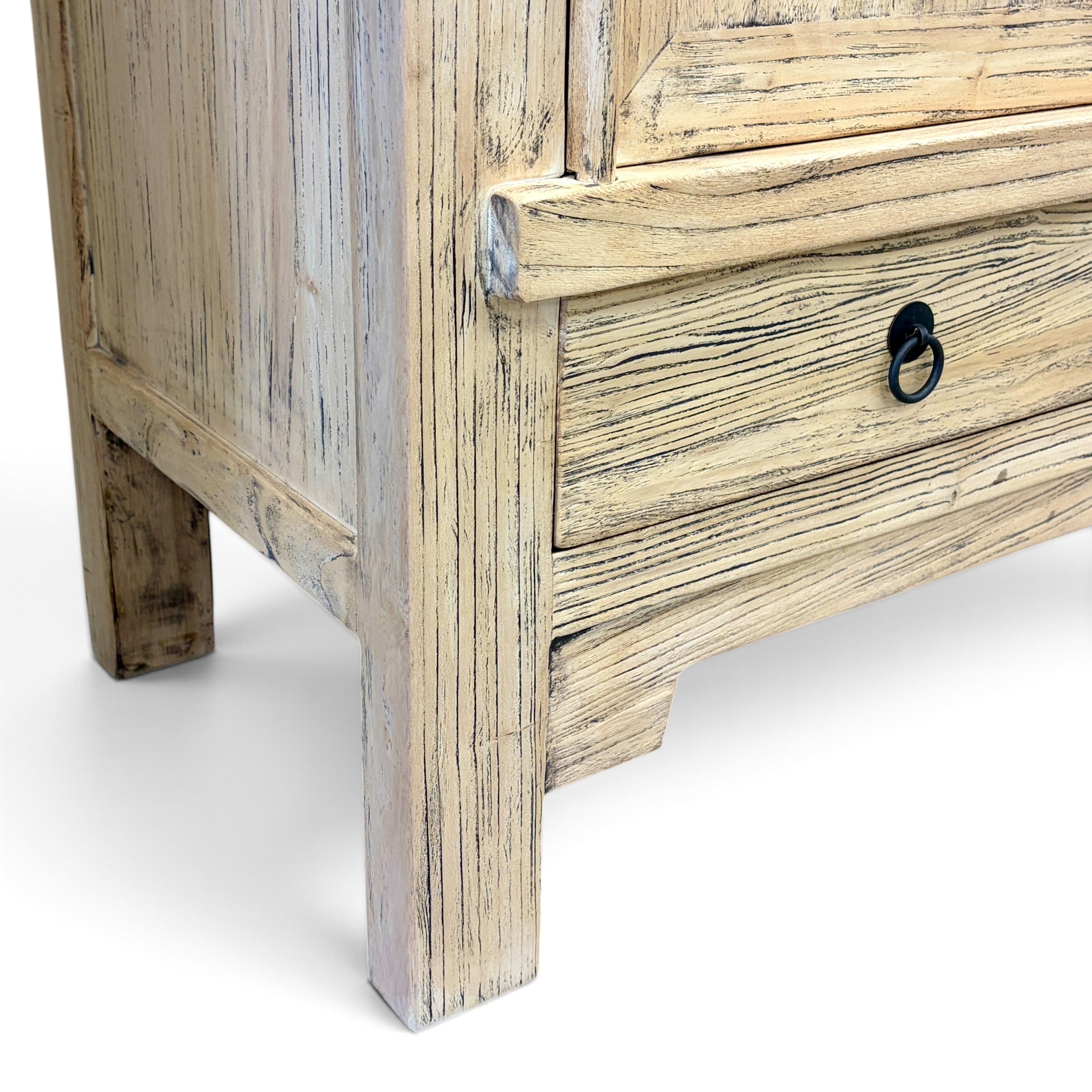Detail of Angus Cabinet in elm showing timber grain, lower drawer and black metal ring handle