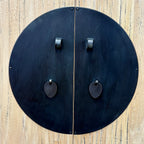Close-up of Angus Cabinet doors showing distinctive round black metal hardware and drop handles