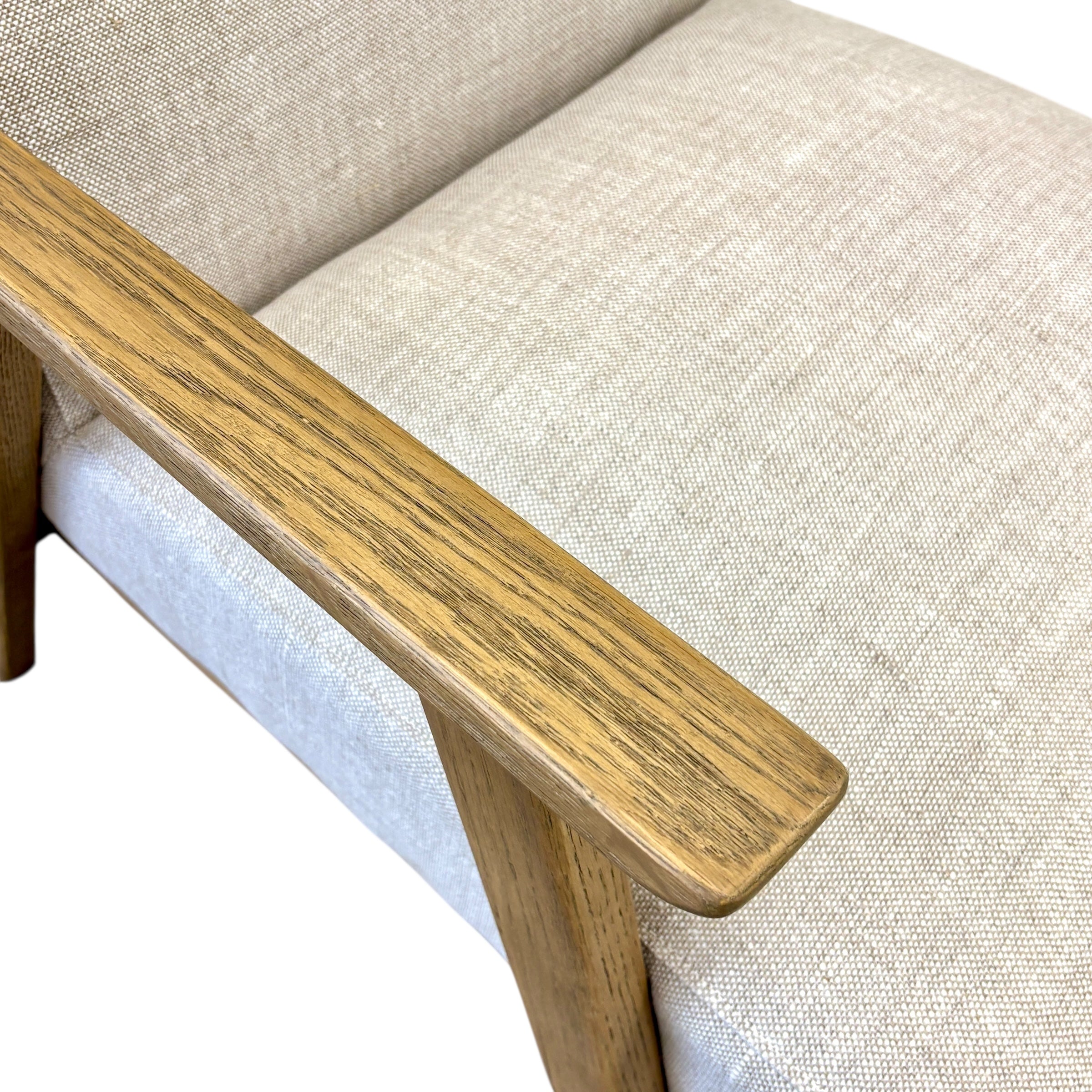 Close-up of the Ascot armchair in Oat, featuring textured linen fabric and solid oak legs.
