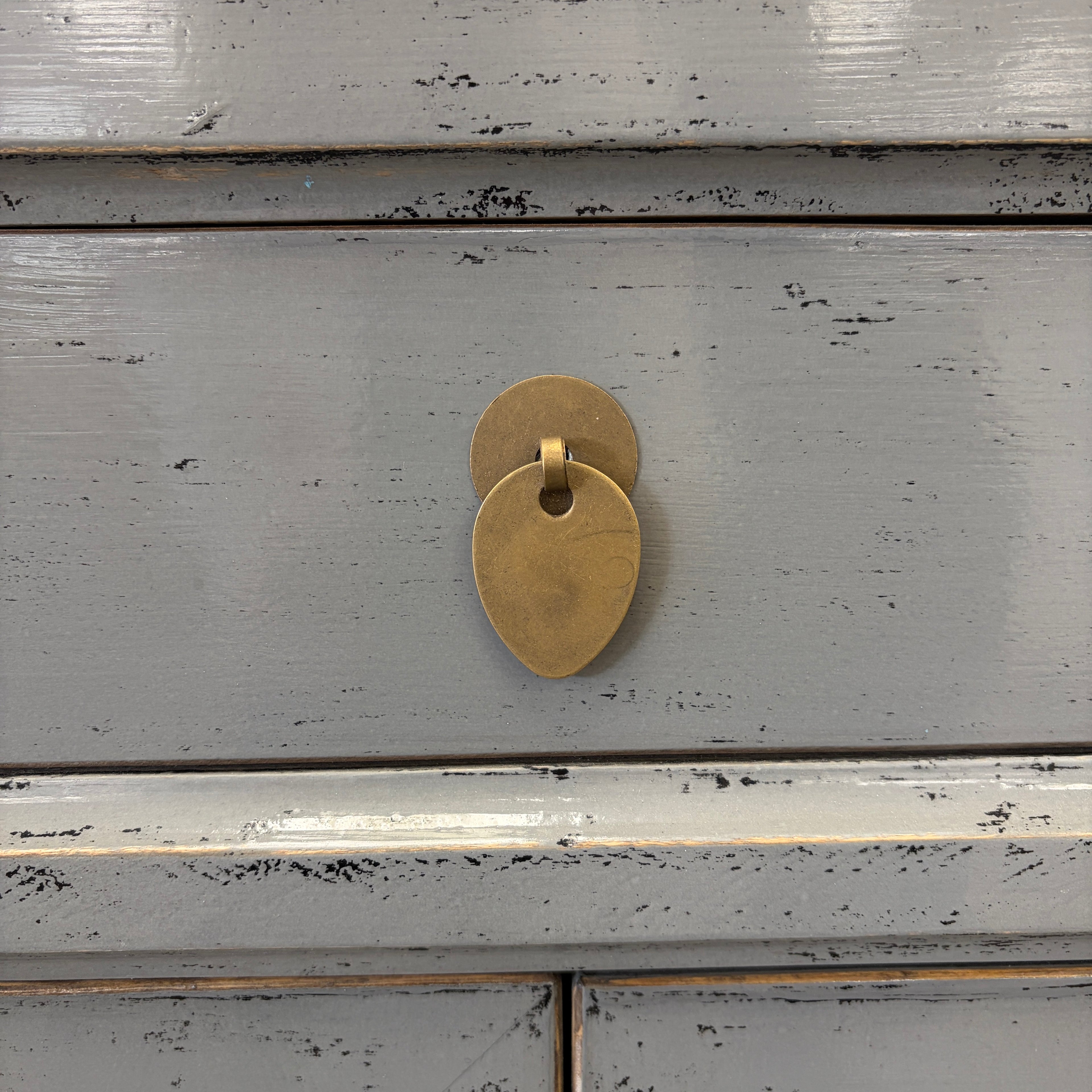 Close-up of distressed glossy grey lacquer finish and brass handle on Far East bedside cabinet