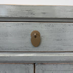 Close-up of distressed sage grey lacquer finish and brass handle on Far East Bedside