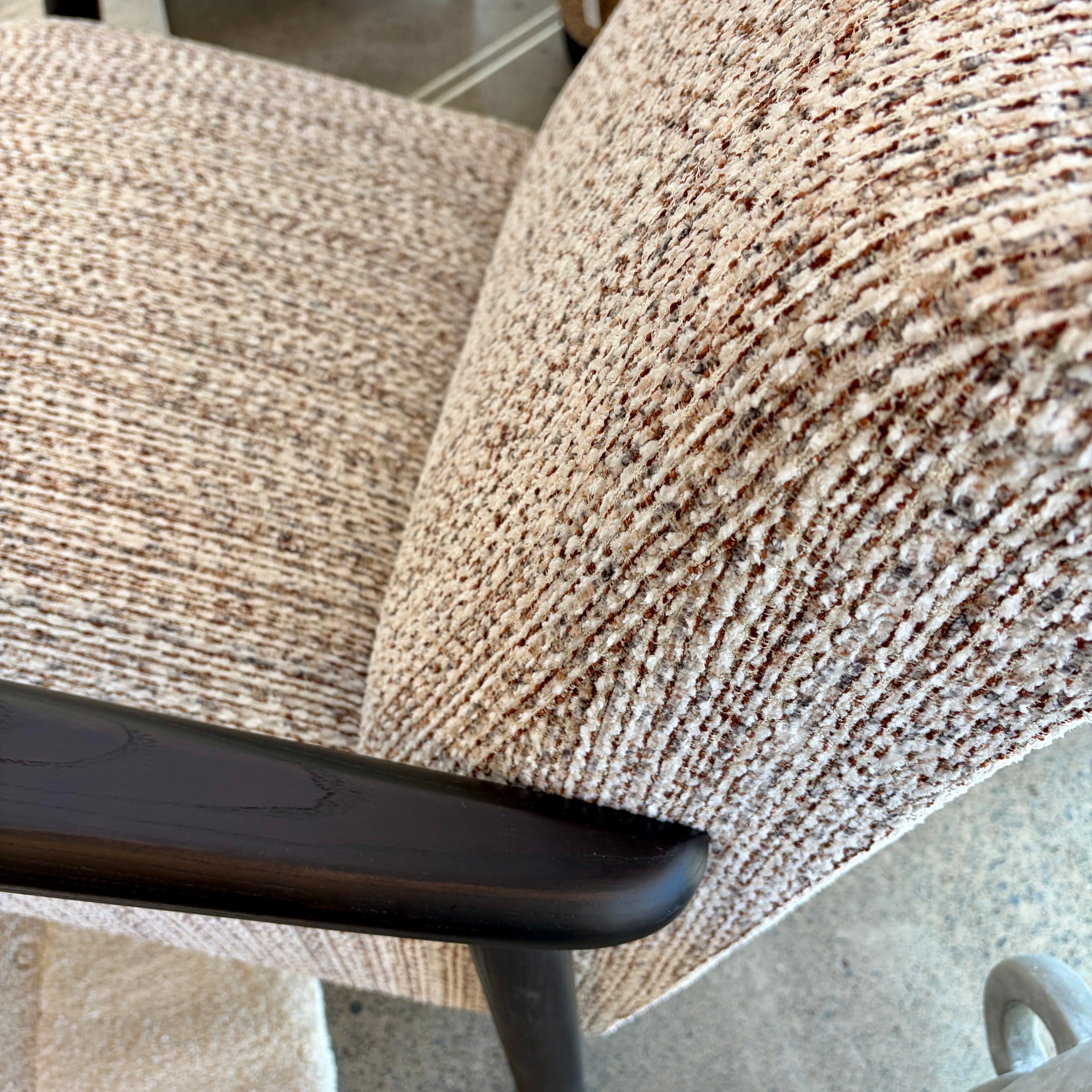 Angled view of the Frankie chair in Nutmeg Cream, showcasing its curved silhouette and upholstered seat.