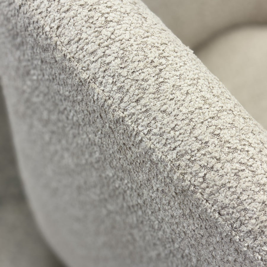 Close-up of the Jenna swivel armchair in Pebble, featuring textured upholstery and contemporary styling.
