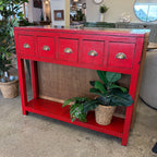 Painted console in bright chili red with five drawers and brass handles.
