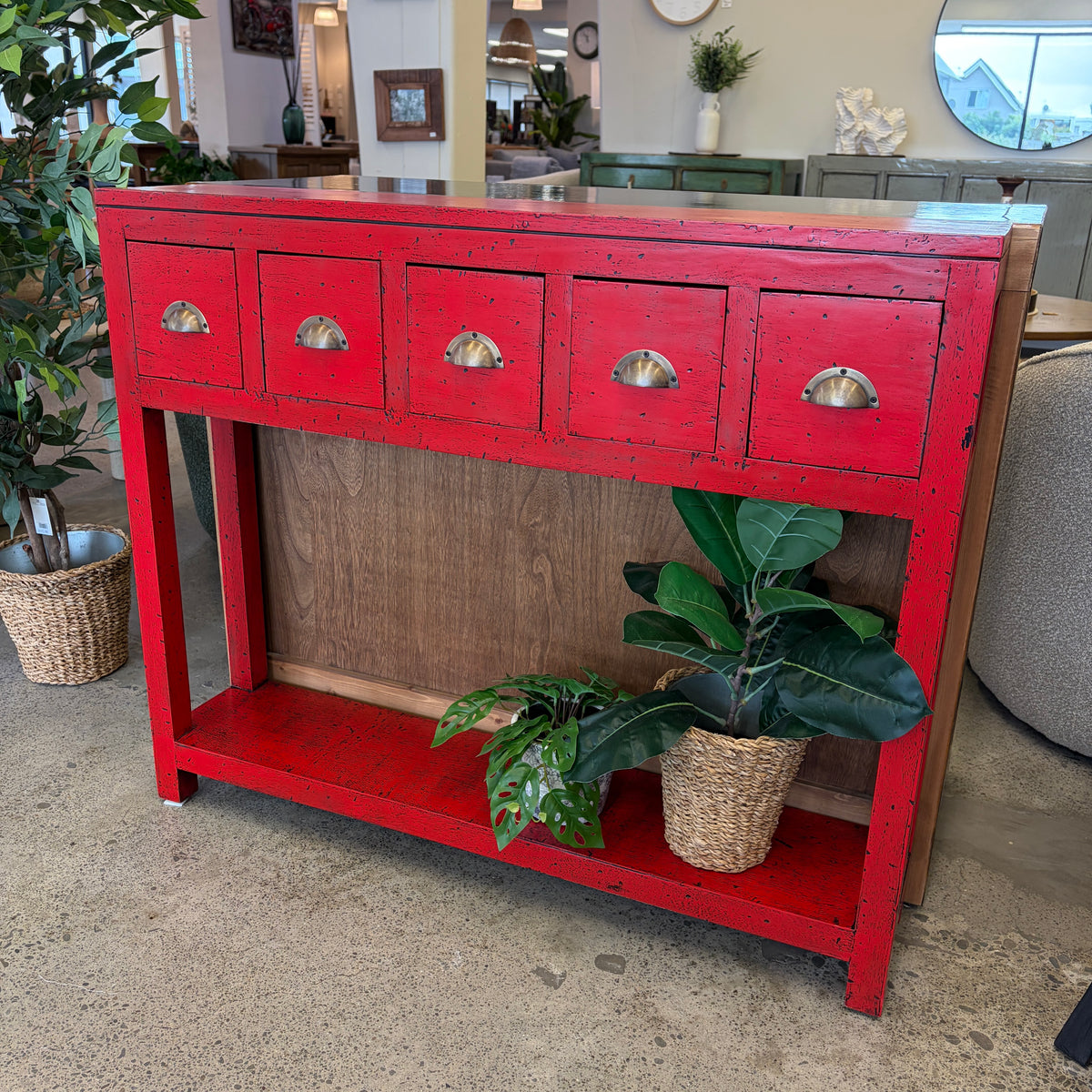 Painted console in bright chili red with five drawers and brass handles.