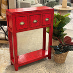 Painted console in bright chili red with three drawers and brass handles.