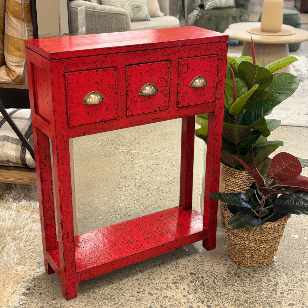 Painted console in bright chili red with three drawers and brass handles.
