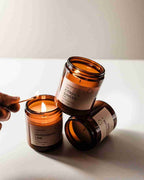 Lantern Cove Glo soy wax candles in amber glass jars, styled with Citrus Ginger and Lemongrass Lime fragrances