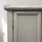 Close-up of Lina cupboard showing distressed white painted finish and panelled door detailing