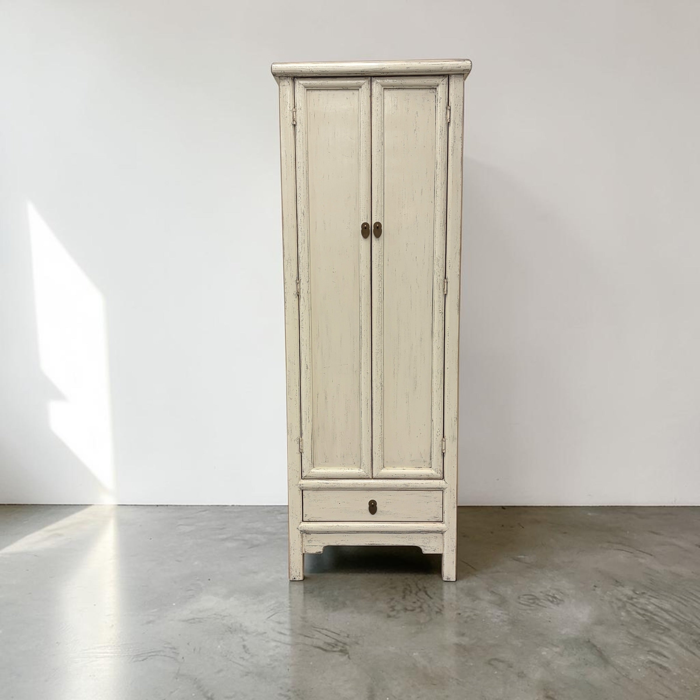 Lina 2 door cupboard in distressed white finish with tall panelled doors, lower drawer and metal handles