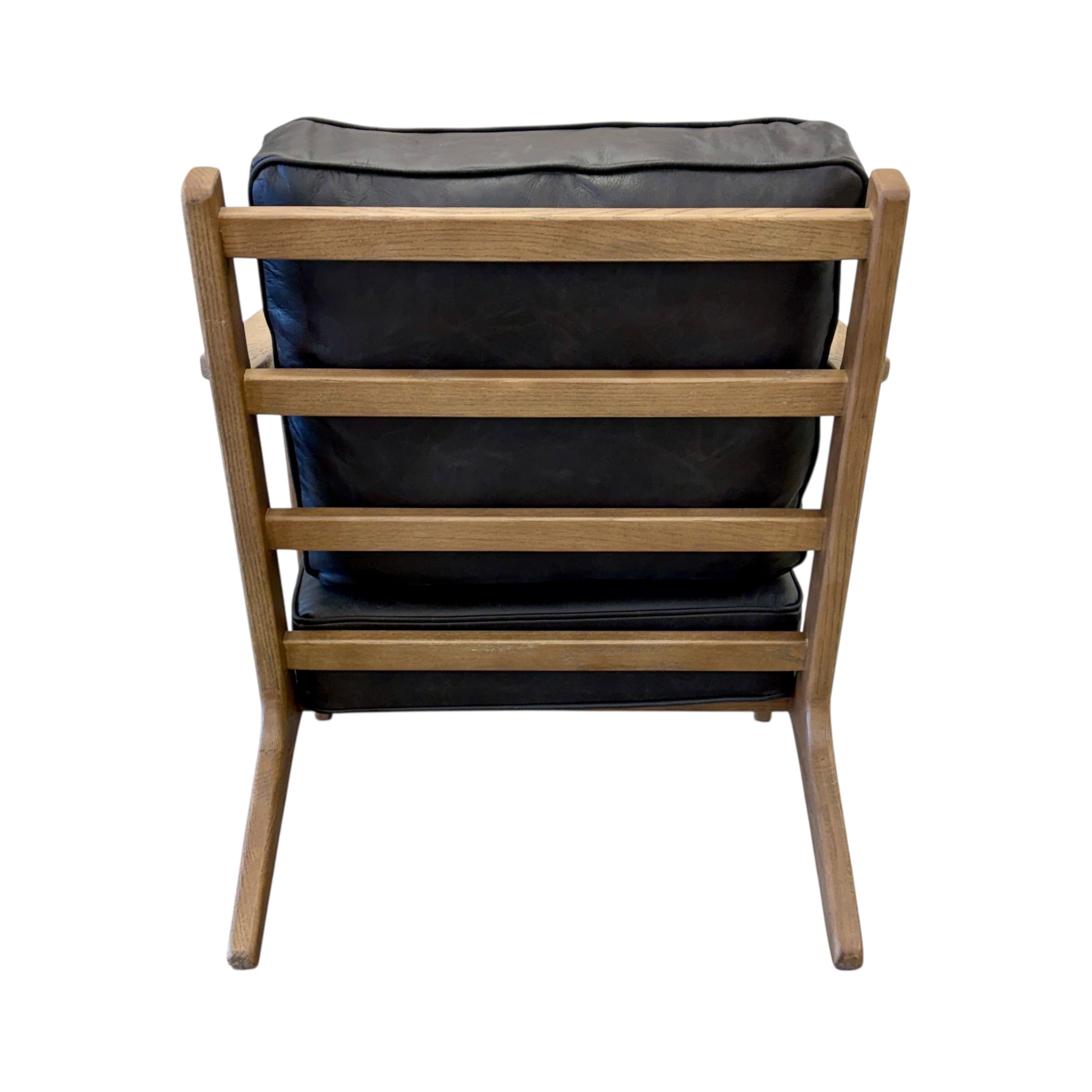 Rear view of the Nero armchair, highlighting its leather upholstery and modern silhouette.