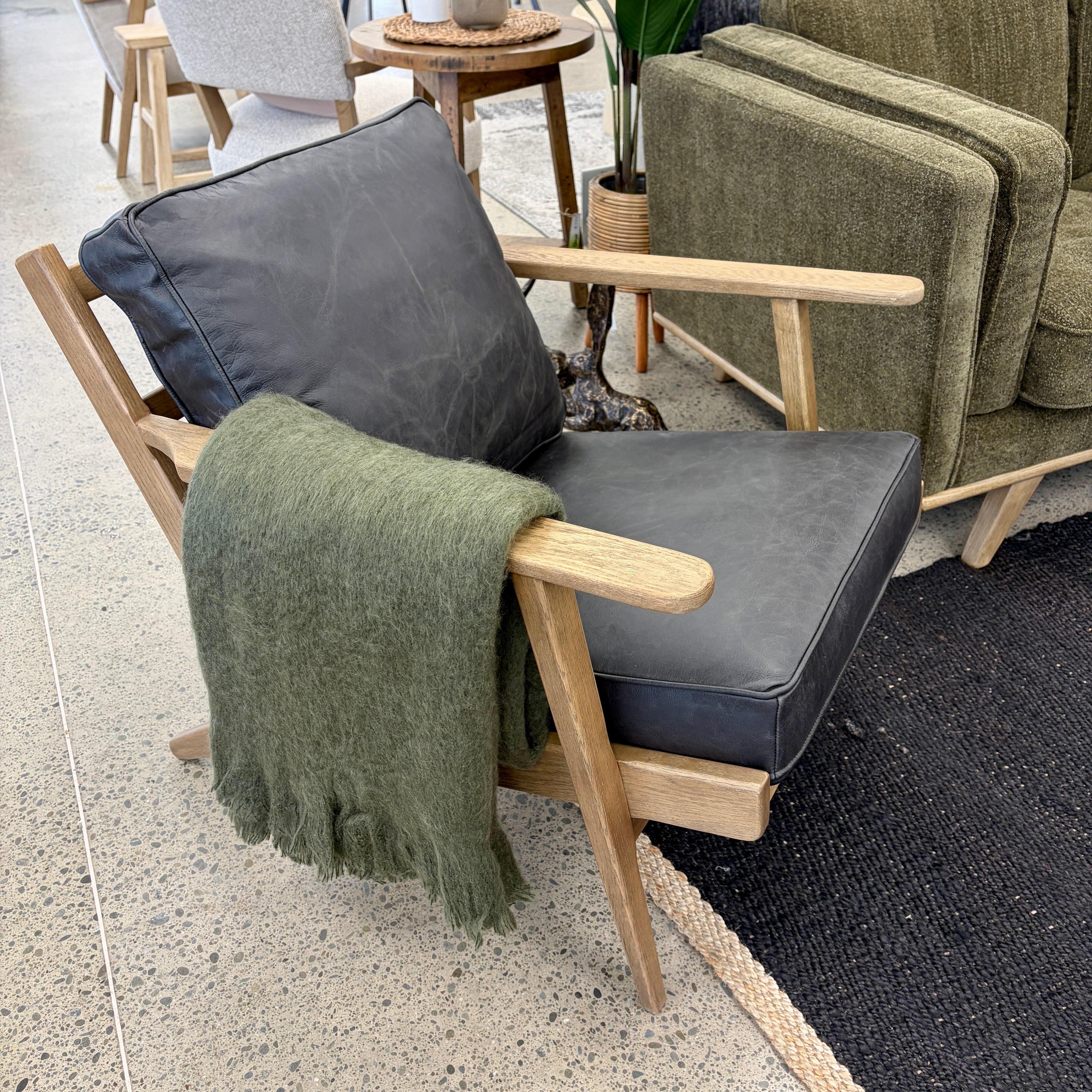Nero armchair styled in a contemporary living room with complementary furniture and décor.