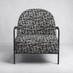 Portia armchair with contemporary curved design and textured fabric upholstery.