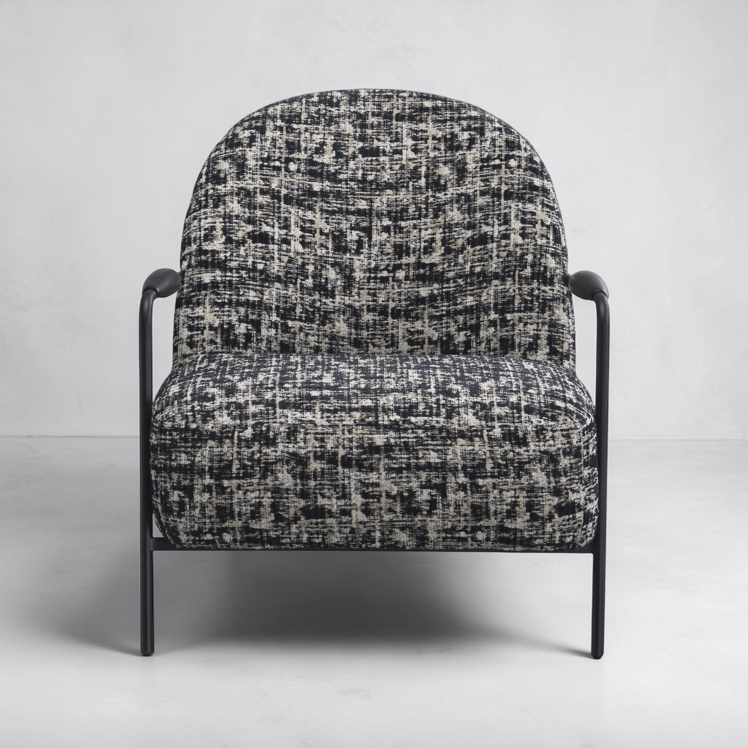 Portia armchair with contemporary curved design and textured fabric upholstery.