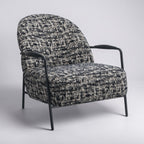 Side profile of the Portia armchair with a curved back and generously cushioned seat.