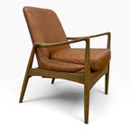 Side angled view of Portobello Chair showing warm toffee leather upholstery and solid oak frame