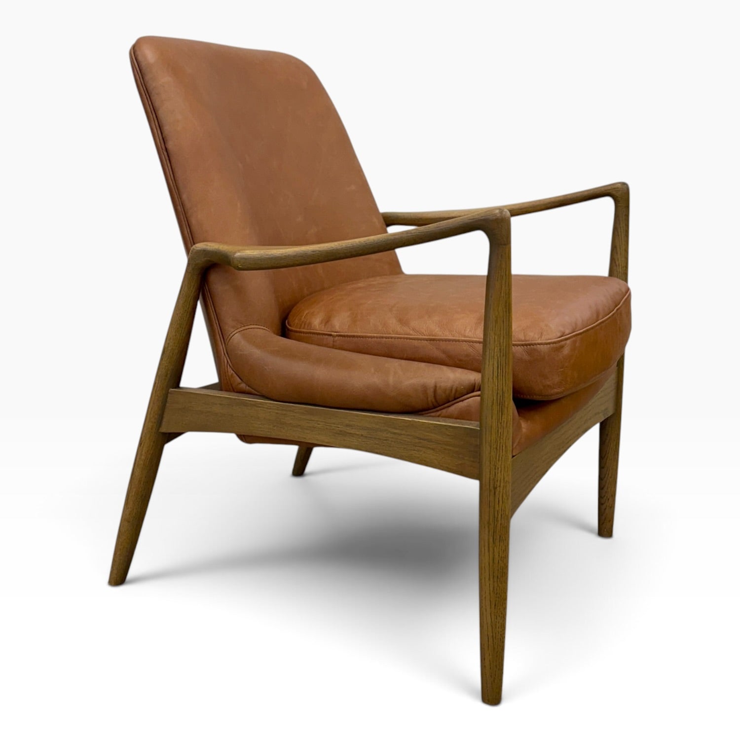 Side angled view of Portobello Chair showing warm toffee leather upholstery and solid oak frame