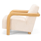 Side profile of the Post armchair with supportive cushioning and solid timber arms.