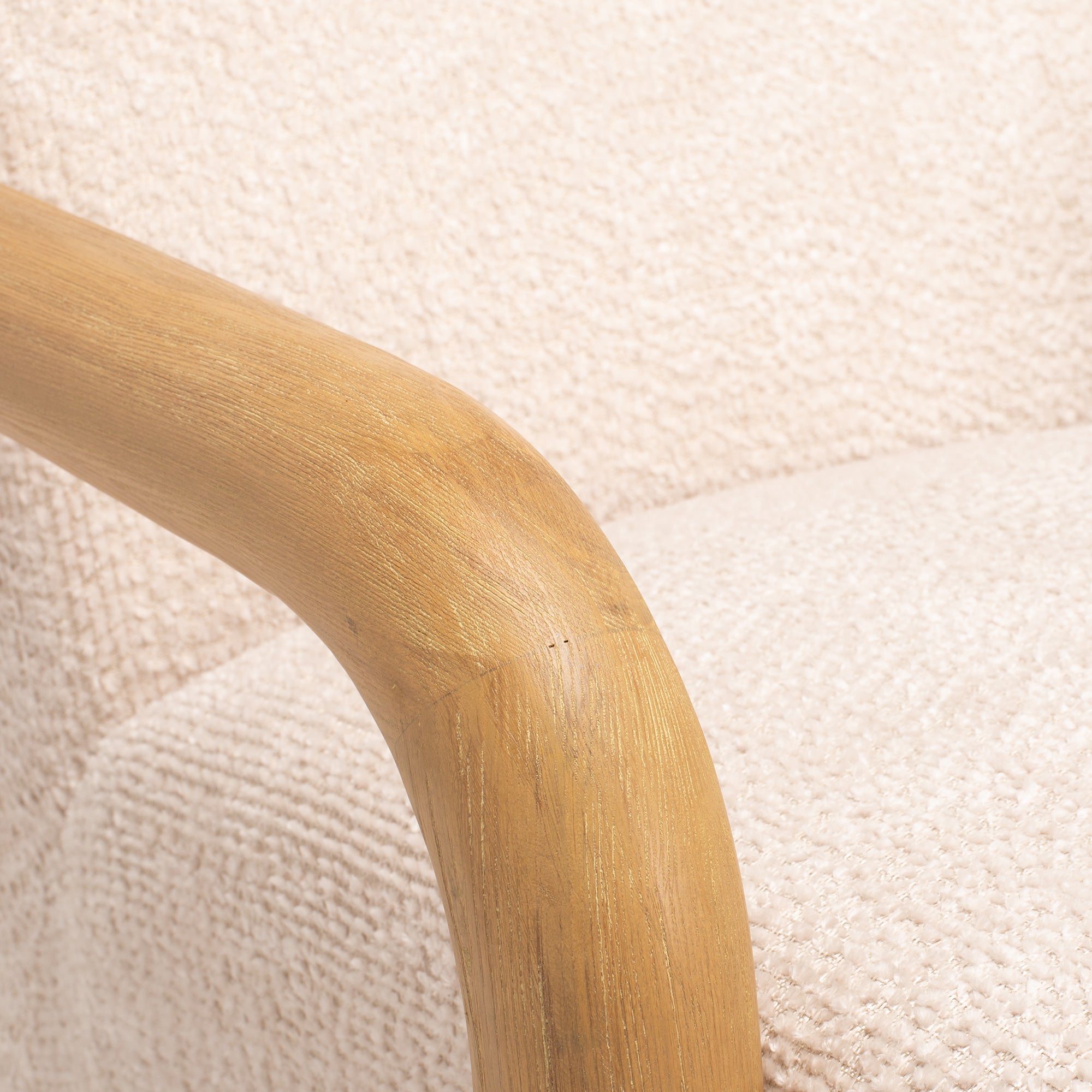Close-up of the Post armchair's solid timber arm, showcasing the natural timber grain and quality craftsmanship.