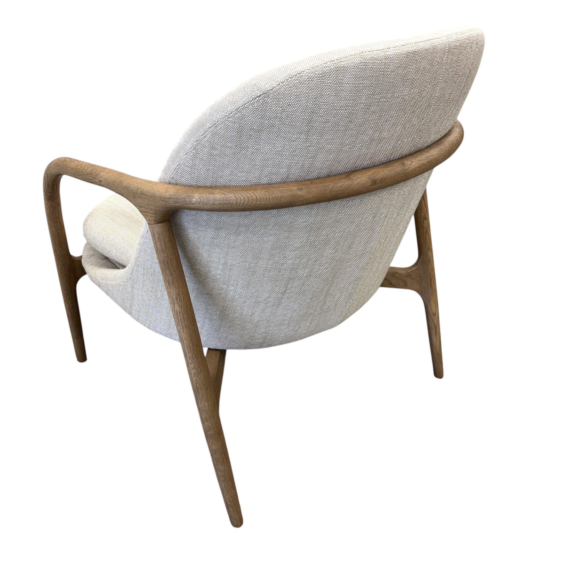 Angled view of the Adeline fabric armchair, showcasing its curved ash frame and natural linen upholstery.