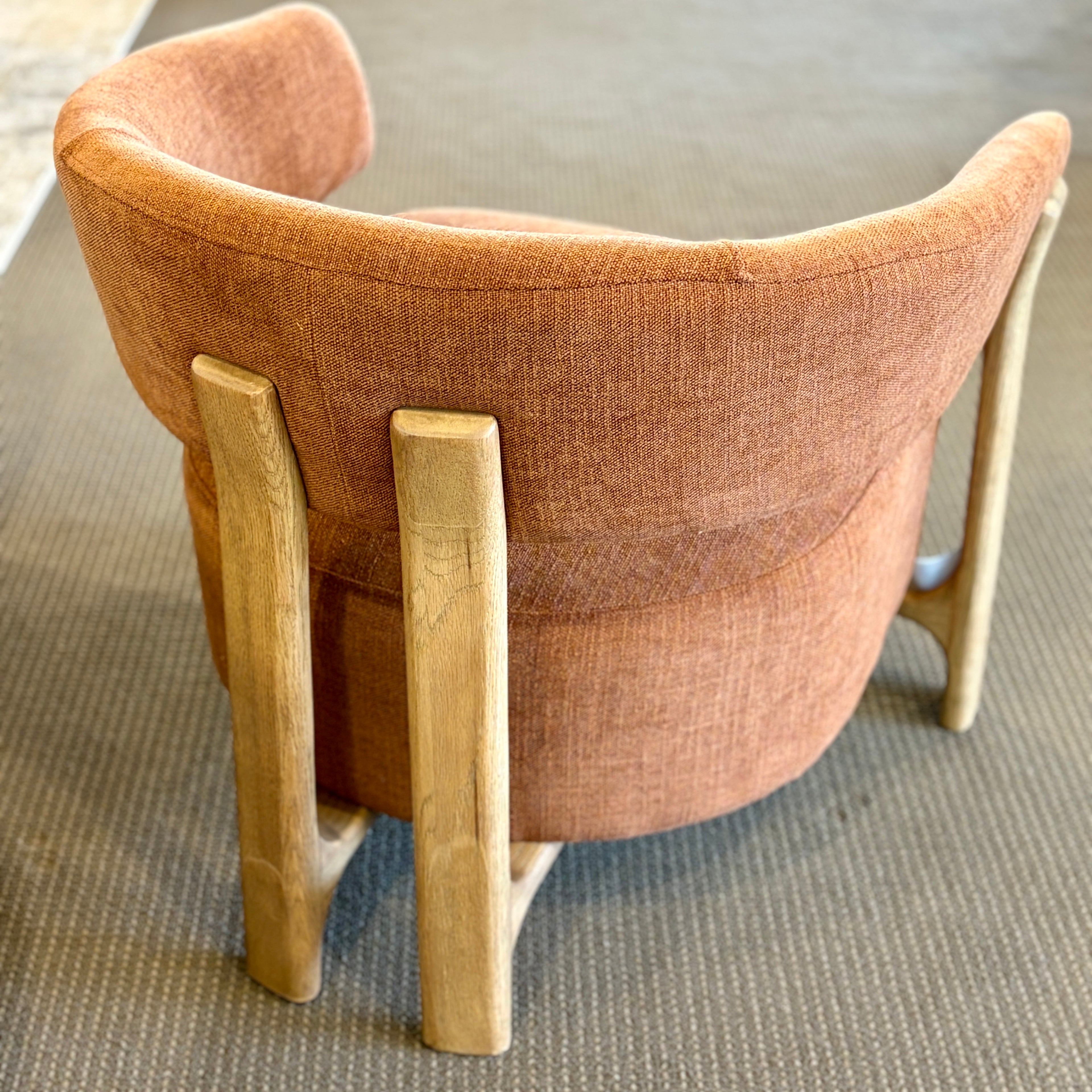 Rear view of the Aiden Chair in Burnt Orange, highlighting its sculptural ash timber frame and curved backrest.