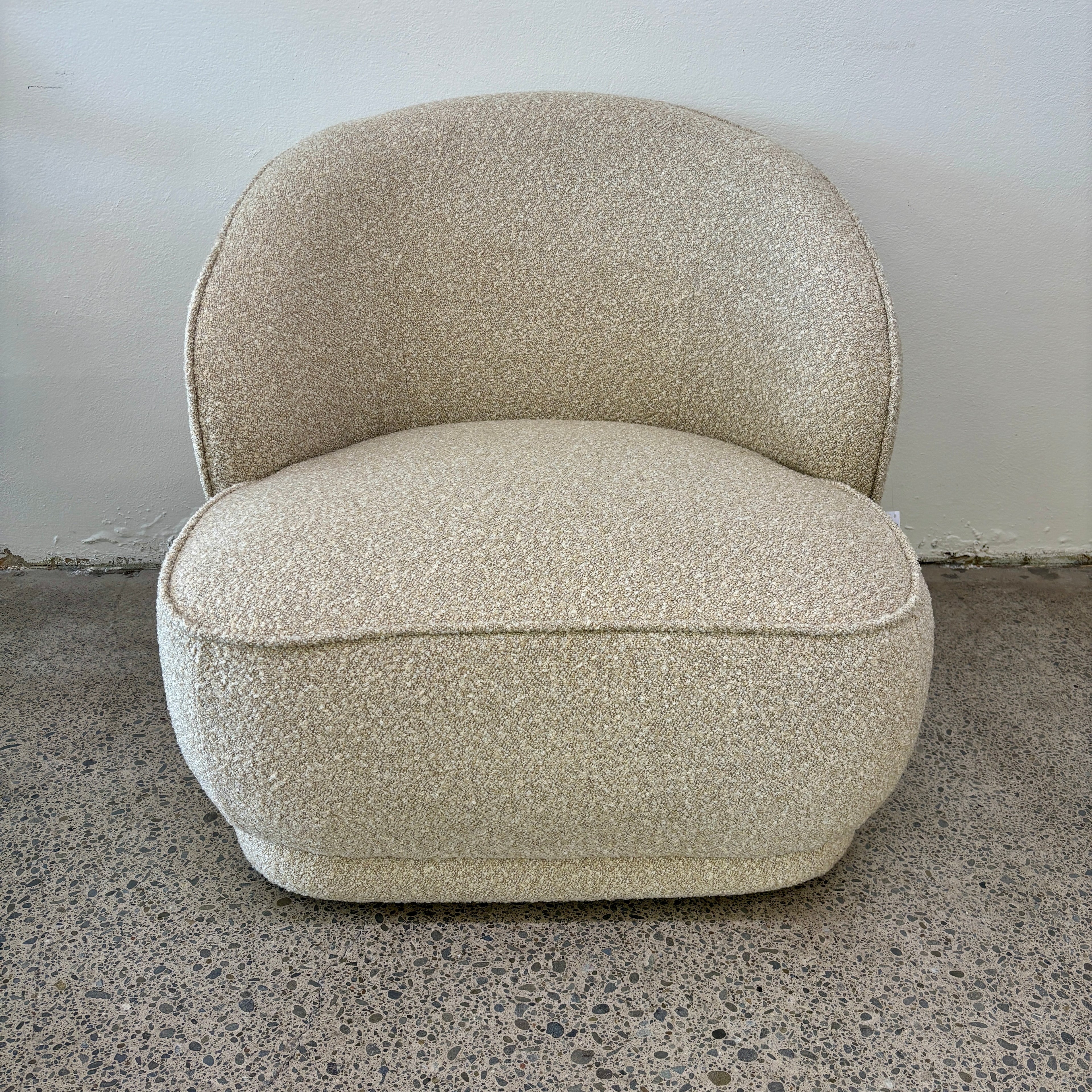 Angled view of the Arlo Chair in Grain with rounded contours, textured upholstery and contemporary styling.