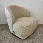 Side profile of the Arlo Chair in Grain, highlighting its wraparound backrest, curved design and deep cushioned seat.