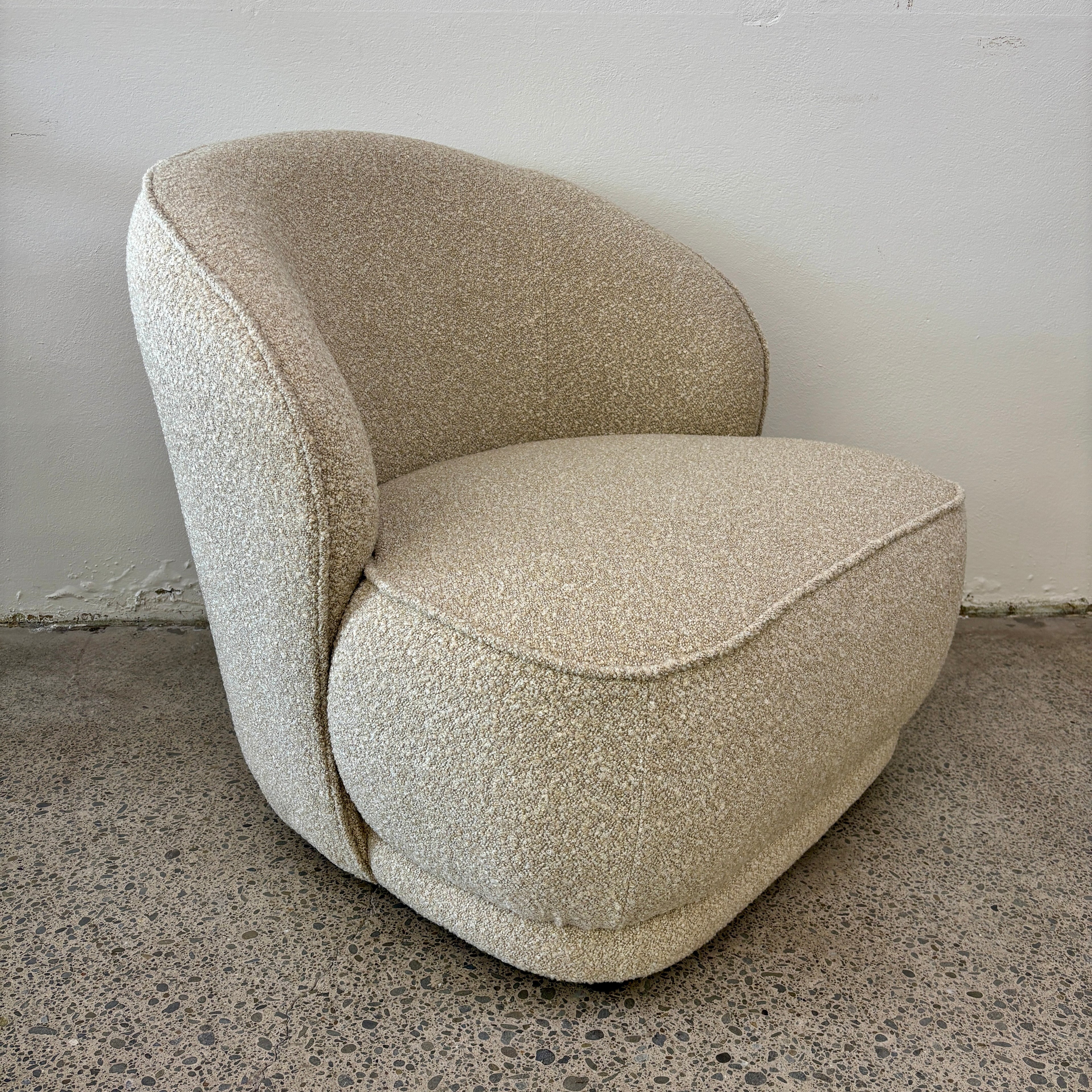 Side profile of the Arlo Chair in Grain, highlighting its wraparound backrest, curved design and deep cushioned seat.