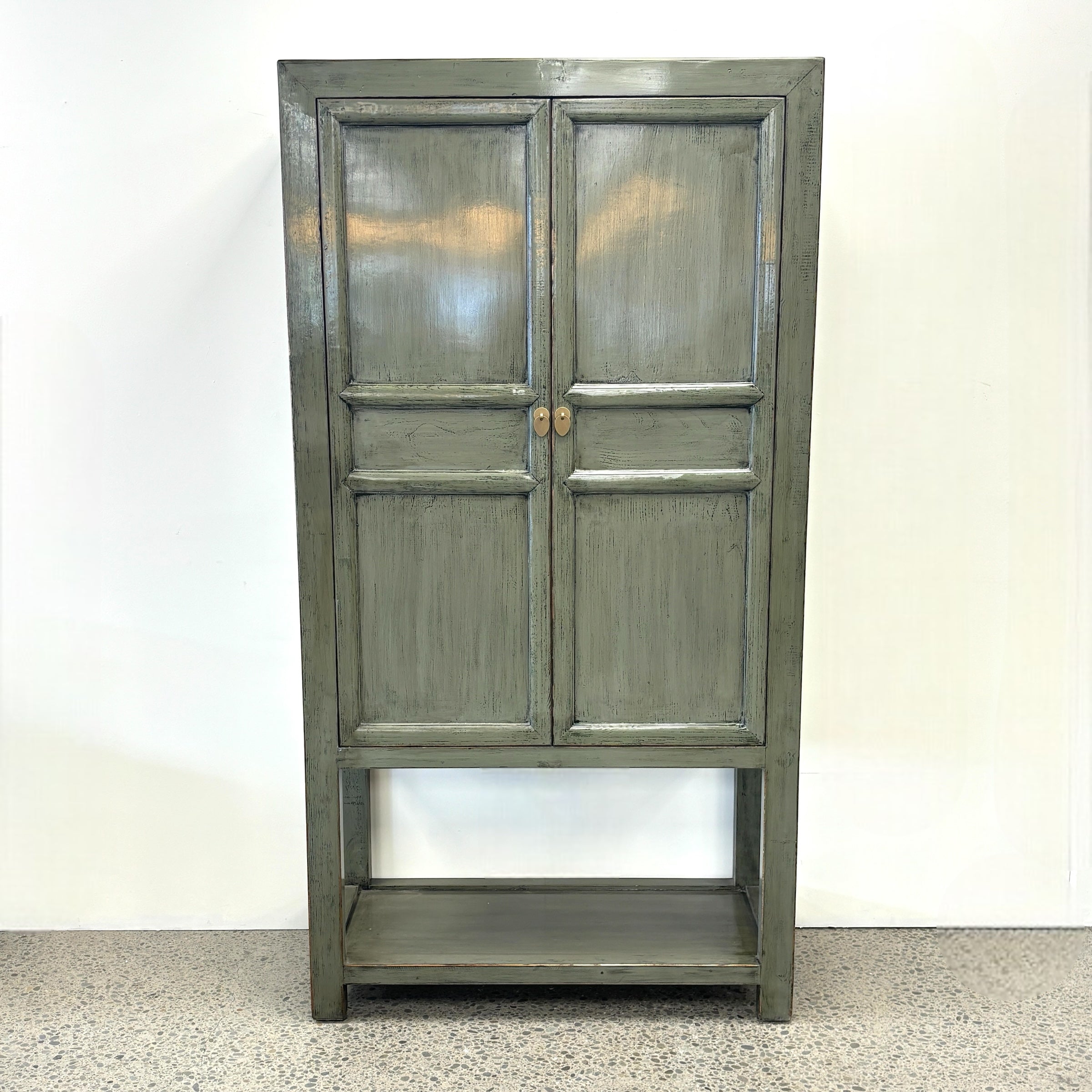 Ayla Storage Cupboard Smoke front view with panelled doors, gold toned handles and open lower shelf