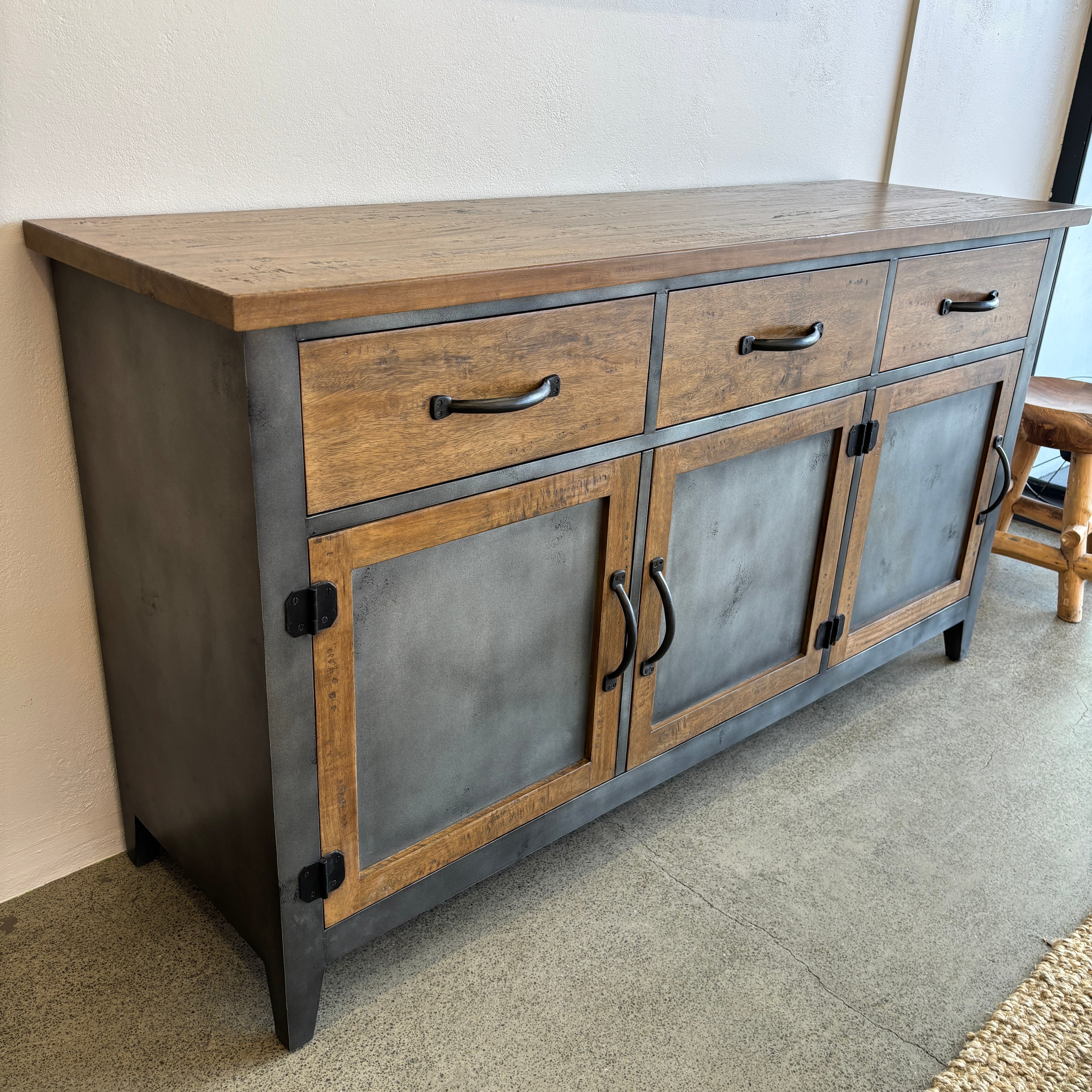 Angled view of Barber 3 Door Sideboard showing mango wood, brushed steel doors and dark metal hardware