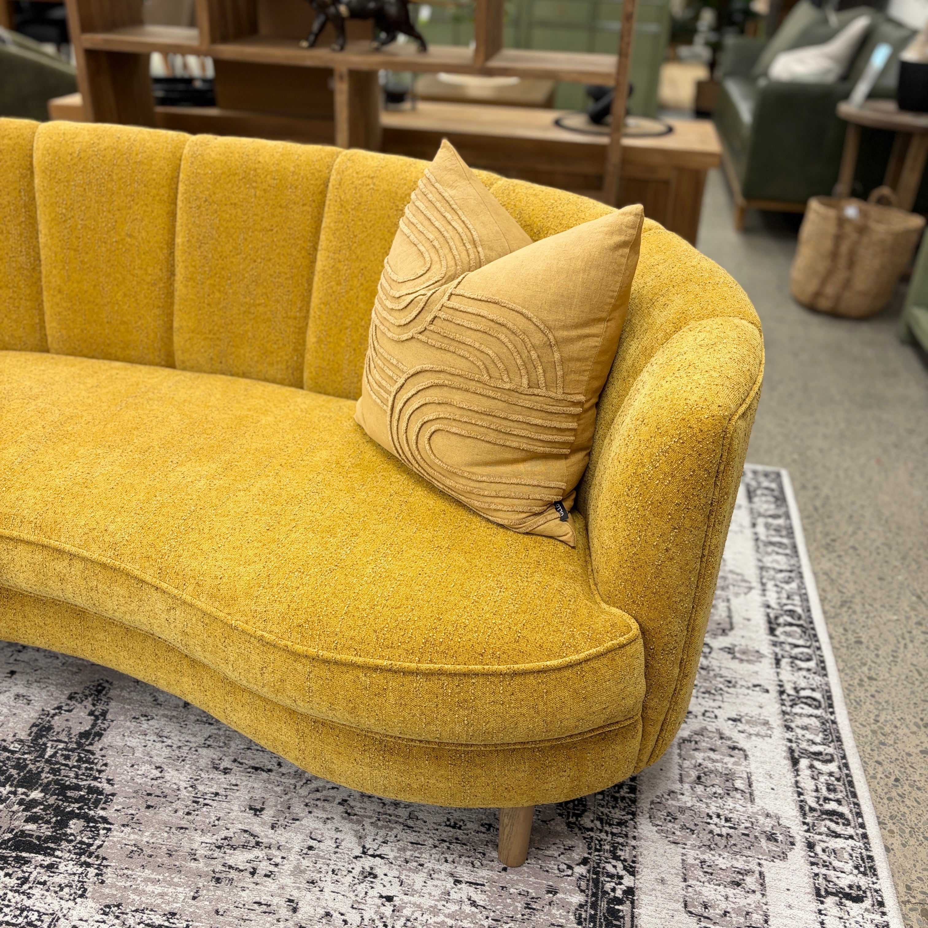 Angled view of the Bardot Sofa in Marigold showcasing its curved frame, channel-tufted backrest and textured upholstery.