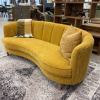 Side profile of the Bardot Sofa in Marigold highlighting its sweeping curved shape, timber legs and contemporary design.