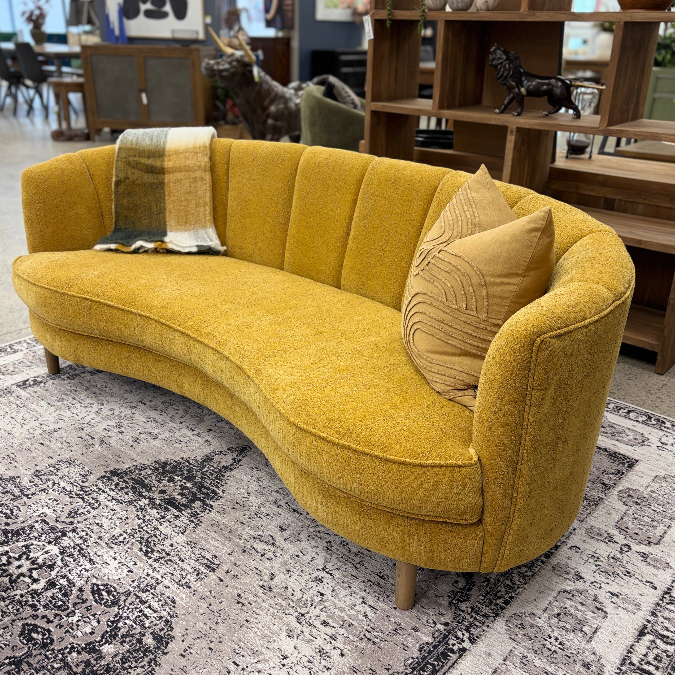 Side profile of the Bardot Sofa in Marigold highlighting its sweeping curved shape, timber legs and contemporary design.