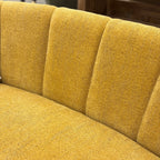 Close-up of the Bardot Sofa, showcasing the textured fabric back rest detail, piping and curved upholstery.