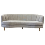 Bardot Sofa in Stone featuring a curved silhouette, channel-stitched backrest and textured woven upholstery.