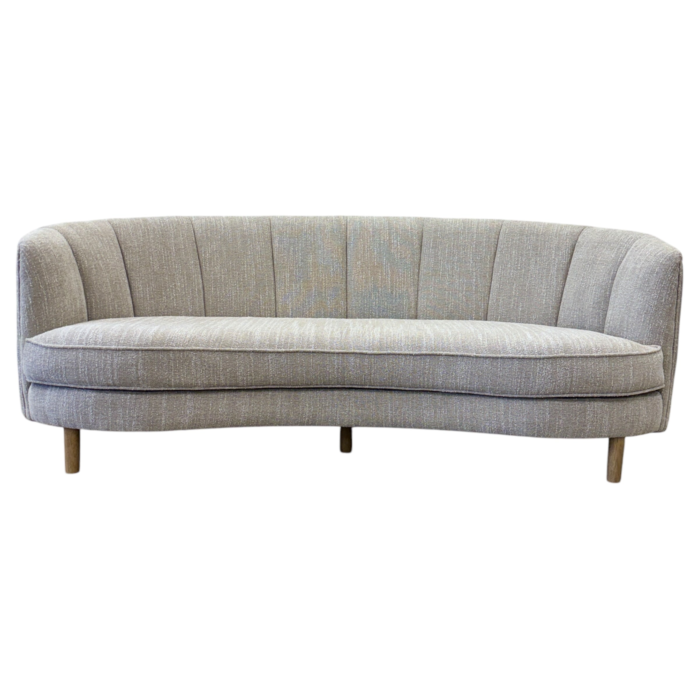 Bardot Sofa in Stone featuring a curved silhouette, channel-stitched backrest and textured woven upholstery.