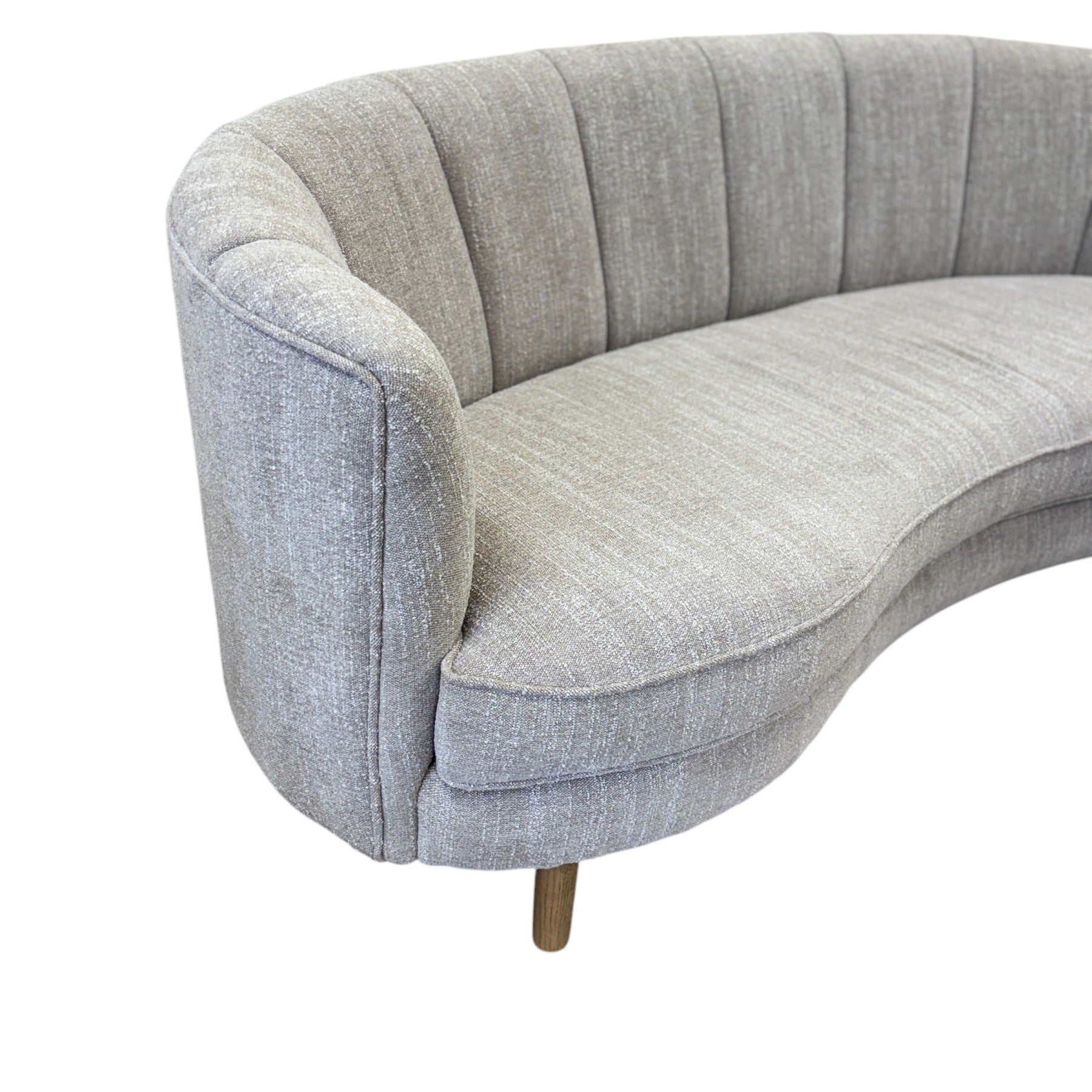 Side profile of the Bardot Sofa in Stone highlighting its curved arms, streamlined silhouette and timber legs.