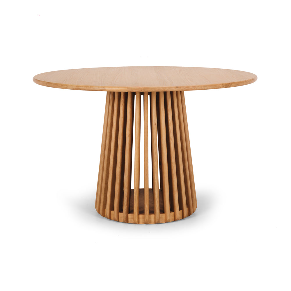 Side view of the Bur Round Dining Table in natural oak, showcasing the sculptural slatted pedestal base and clean Japandi-inspired design.