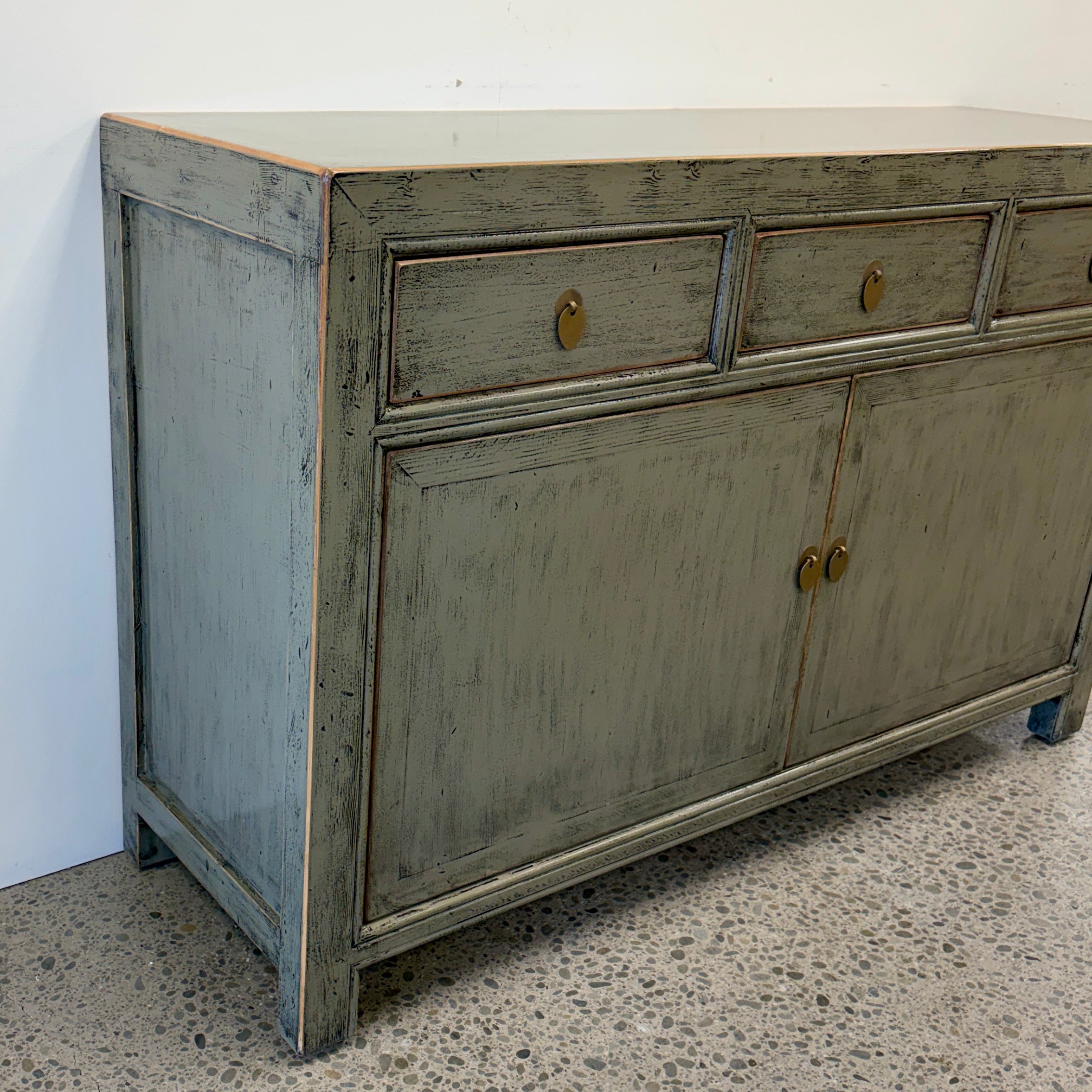 Angled view of Cass Sideboard Sage Grey with distressed finish and brass toned handles