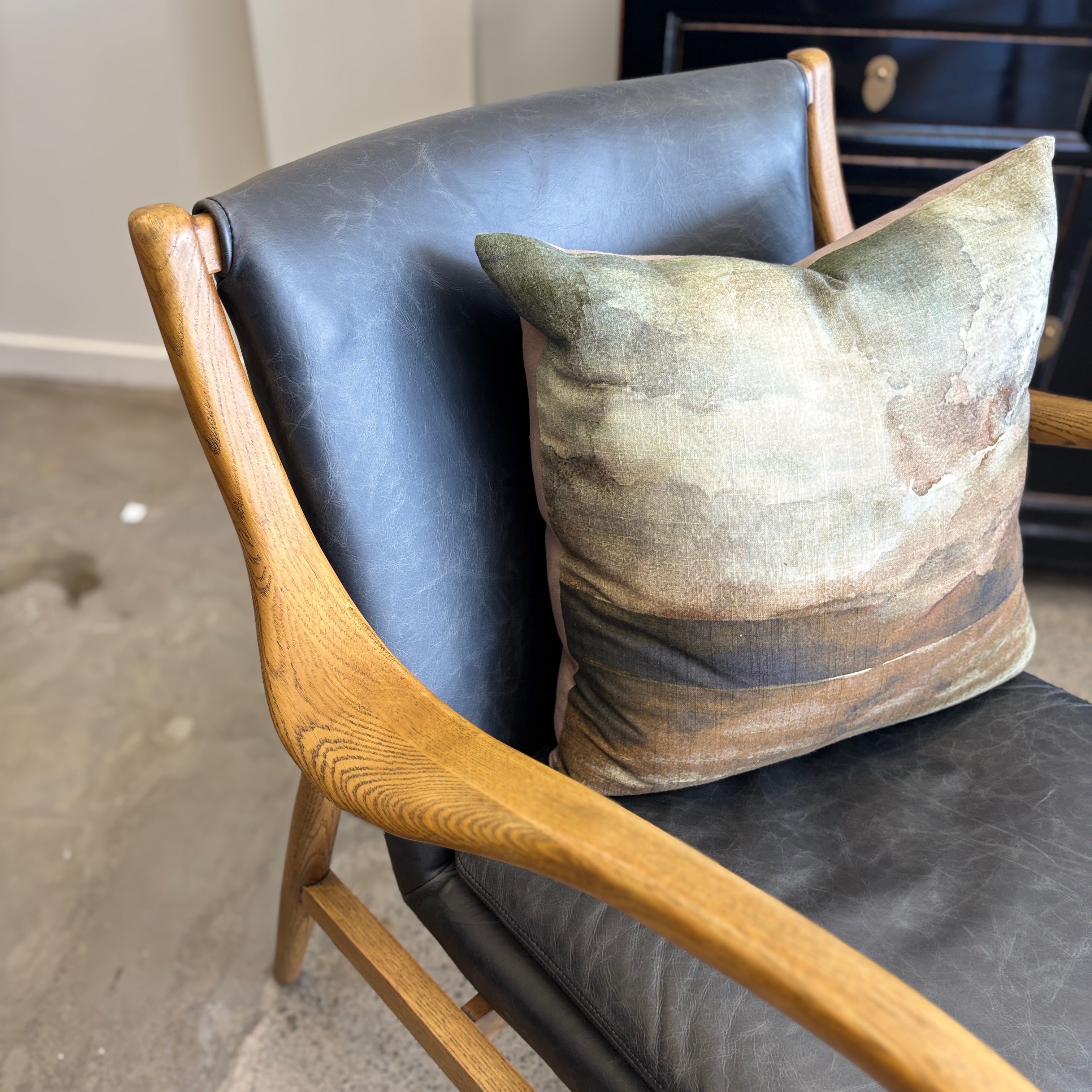 Close-up of the Coco Occasional Chair's curved solid timber arm, showcasing the natural timber grain and quality craftsmanship.