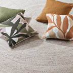 Elena Indoor Outdoor Cushion in Fern styled with green and warm-toned outdoor cushions