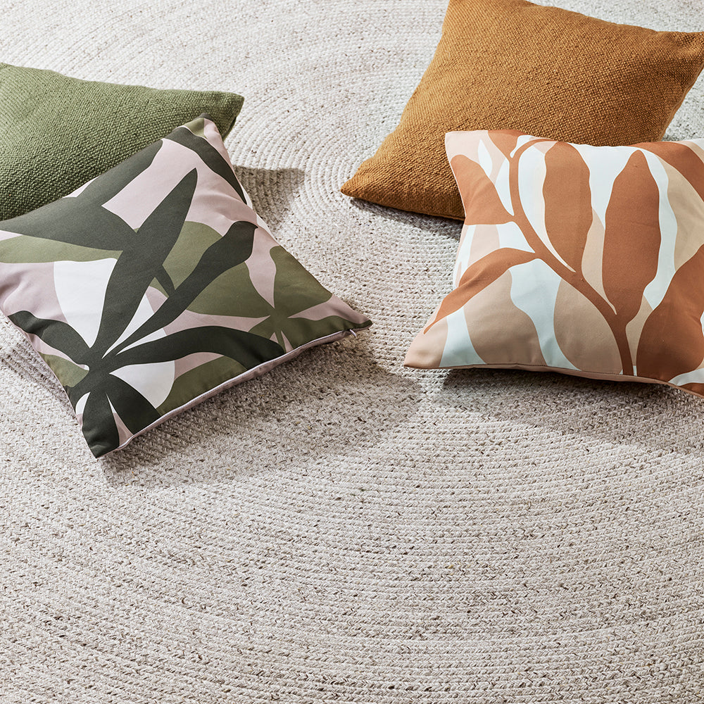 Elena Indoor Outdoor Cushion in Fern styled with green and warm-toned outdoor cushions