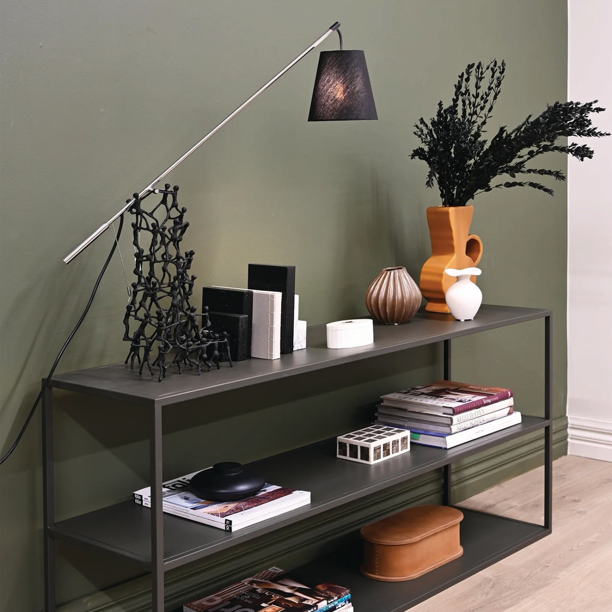 Ellis Low Profile Shelf styled with books, decorative objects and vases against a green wall