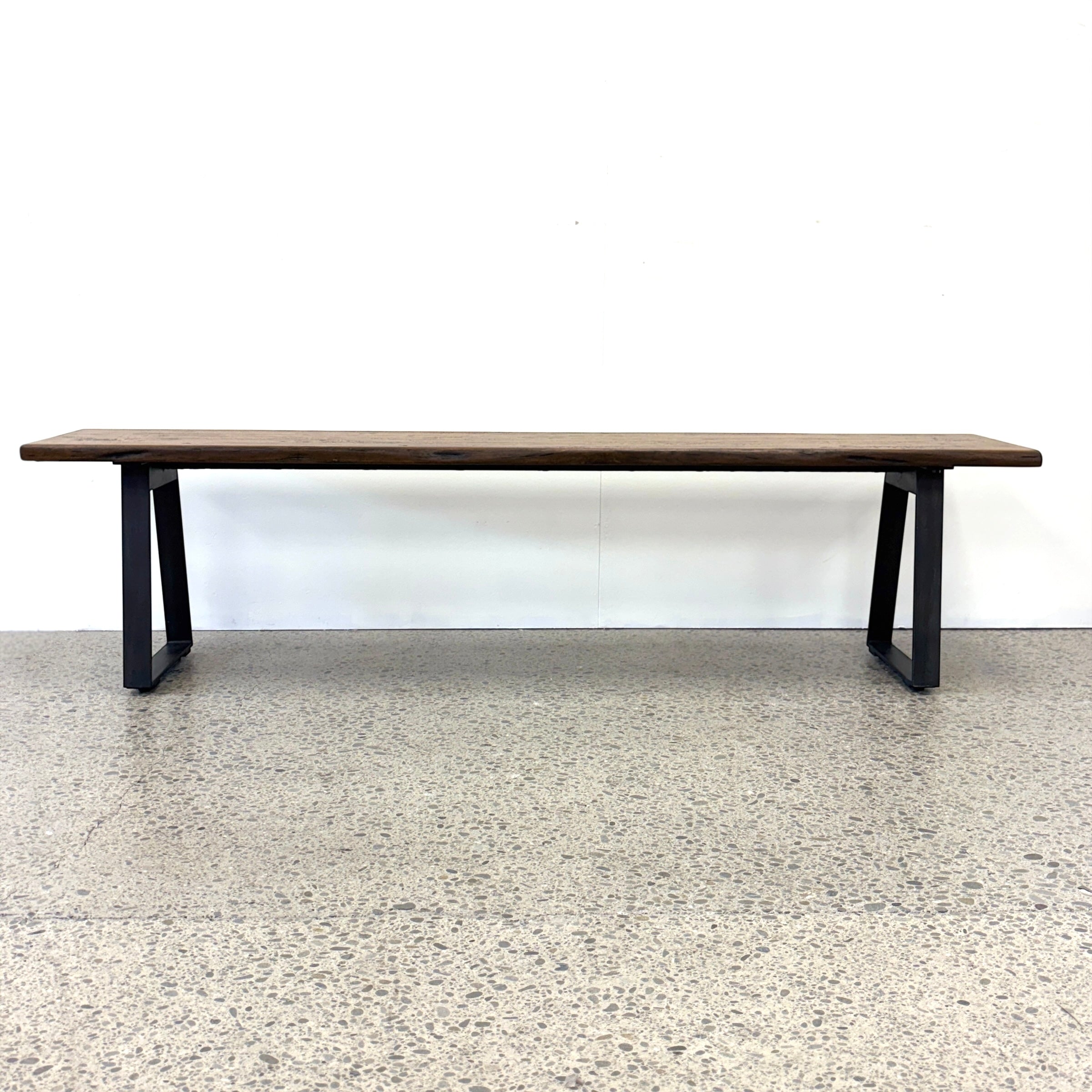 Front view of the Evolution Albany mango wood bench seat with black iron legs