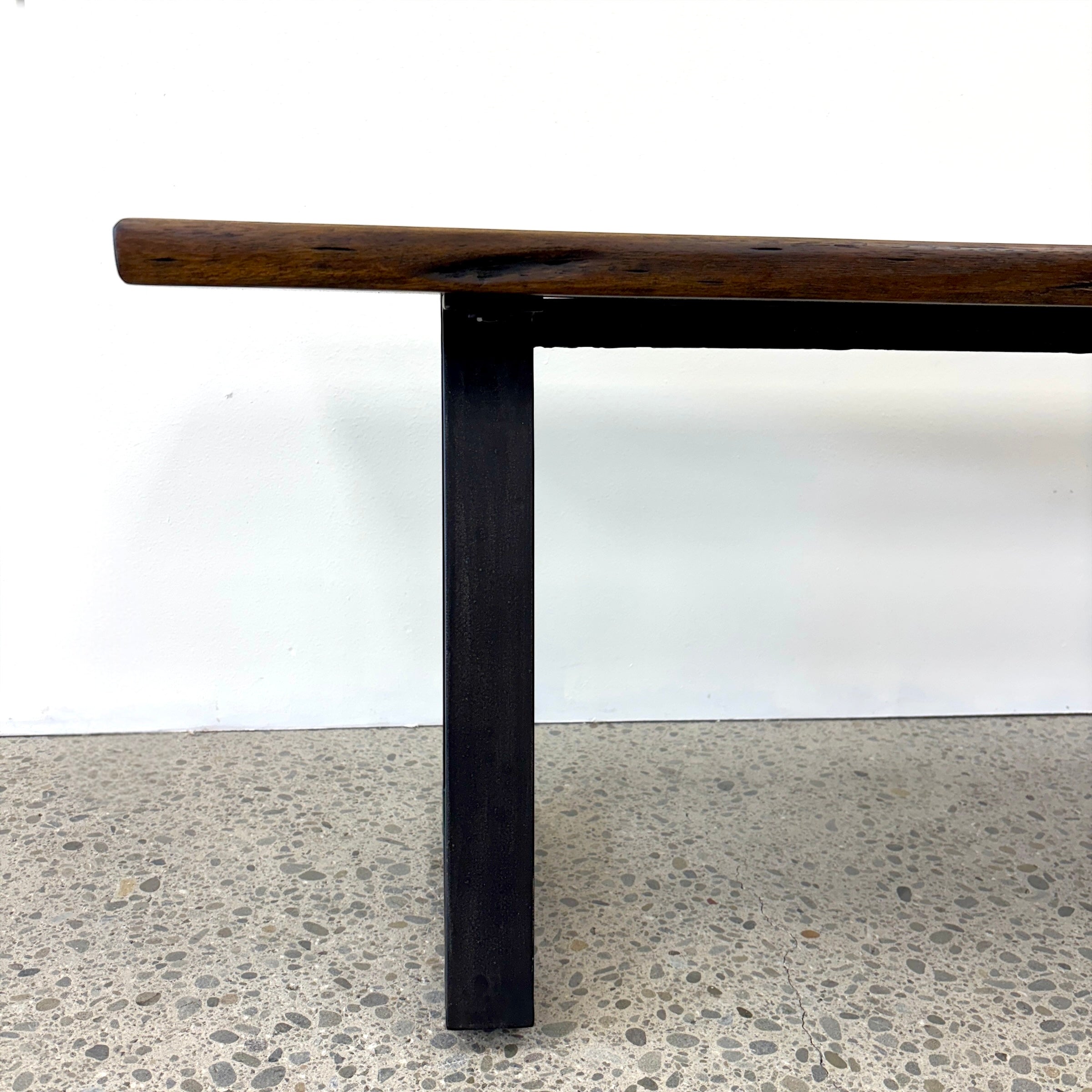 Side profile of the Evolution Albany bench seat showing the mango wood seat and black iron leg