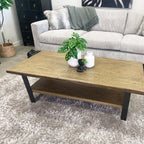 Angled view of the Evolution Coffee Table crafted from solid mango wood with black iron bracing and a lower shelf.