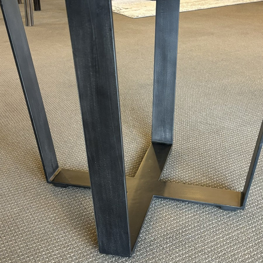 Close-up of the Evolution Round Dining Table's contemporary iron leg, highlighting the sturdy geometric base and durable powder-coated finish.