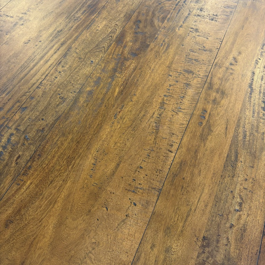 Close-up of the Evolution Round Dining Table's solid mango wood top, highlighting the natural timber grain and rustic Albany finish.