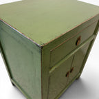 Close-up of Far East Bedside showing olive green painted finish and distressed timber edges