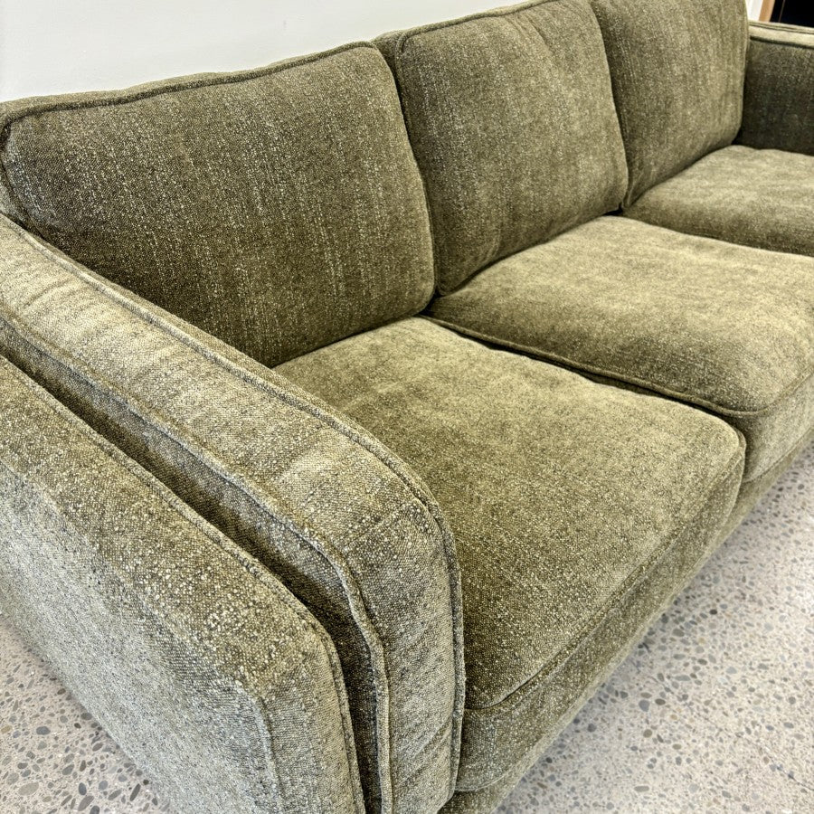 Angled view of the Fergus 3 Seat Sofa in Plush Olive, highlighting its deep seating, soft plush fabric and modern design.